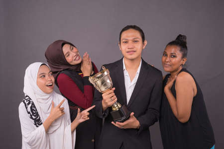 A group of professional worker holding a gold trophy and celebrating their victory.Business concept.の写真素材