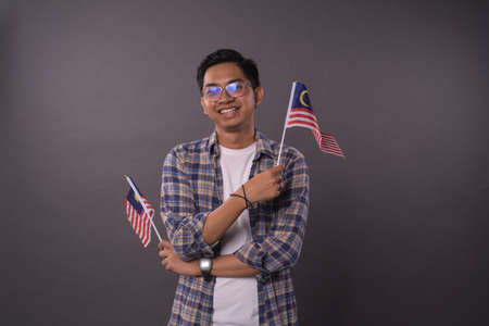 Happy Malaysian teenager holding Malaysia Flag.Independence day and patriotic concept.Studio Shot.の写真素材