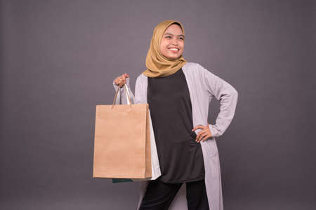 Happy malay girl holding shopping bags.の写真素材