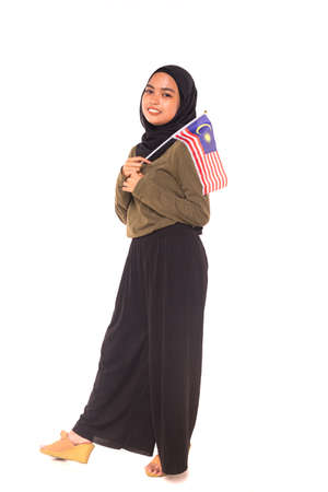 Happy young Malaysian girl holding Malaysia Flag isolated over white background.Independence Day concept.の写真素材