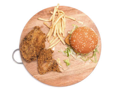 Fried chickens,cheese burger with fries on wooden chopping board isolated over white background.の写真素材