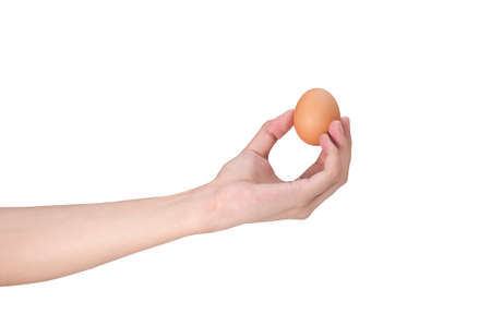 Close up shot of woman's hand holding an egg isolated over white background.Chicken egg.の写真素材