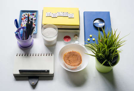 Notebook, magnifying glass and few other stationery objects on white table.View from top.Education concept.の写真素材