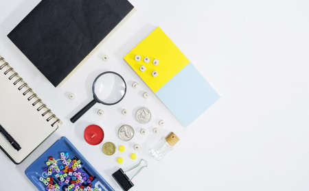 Notebook, magnifying glass and few other stationery objects on white table.View from top.Education concept.の写真素材