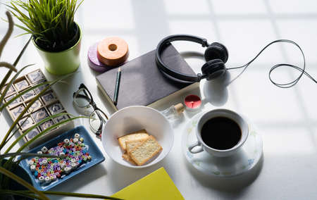 Top view of breakfast menu on white dining table.Coffee,milk, cereal, apple,cracker and bun on white table view from top.Food lay flat concept.の写真素材