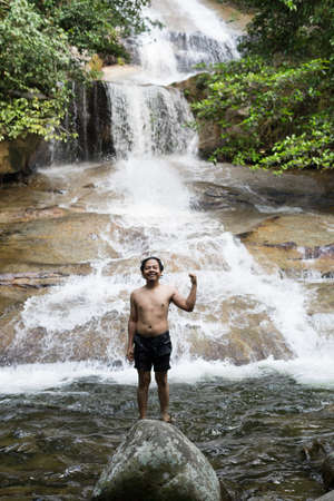 22nd September 2020,Shah Alam Selangor.A teenager in the waterfall pool.Male hiker enjoying the view of rain forest waterfall.のeditorial素材