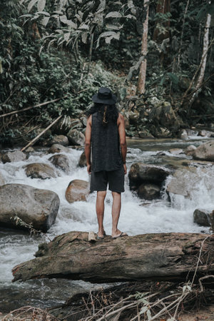 Male traveler hiking along side the river in the rainforest jungle.の写真素材