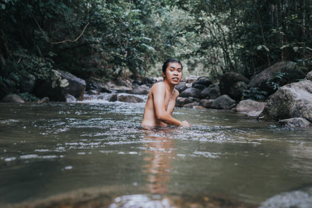 A male traveler in the rain forest pool stream or waterfall.Healthy and active lifestyle.Camping and hiking.の写真素材