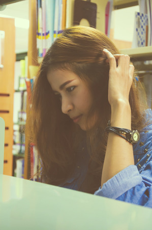 Portrait of asia student looking for a bookの写真素材