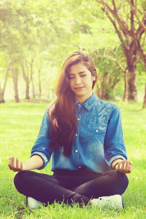 She have a happy with meditating in parkの写真素材