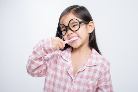 little girl Asia brushing teeth happily white backgroundの写真素材