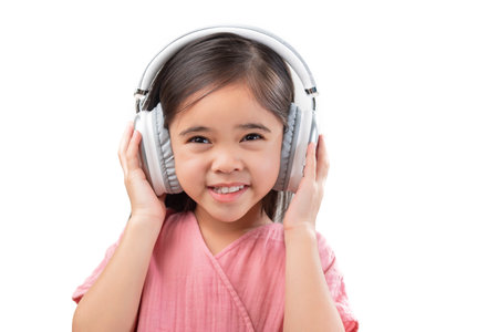 A little beautiful girl asia putting the headphone isolated on a white background.の写真素材