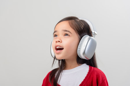 Lttle girl Asia cute enjoying her music headphones (isolated on white)の写真素材