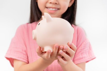 girl hands hold a pink piggy bank . The concept of saving money or savings, investment on white backgrandの写真素材