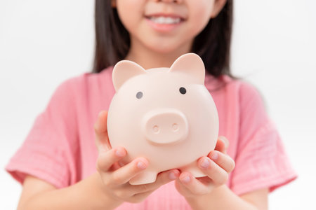 girl hands hold a pink piggy bank . The concept of saving money or savings, investment on white backgrandの写真素材