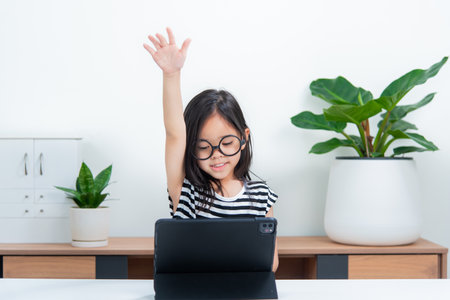 Asian child girl student wow excited on video call learning to studying online class or person learn from home school with tabletの写真素材