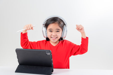 little girl asia cute put on headphones have video call distant class with teacher using laptop,  study online on computer, homeschooling conceptの写真素材