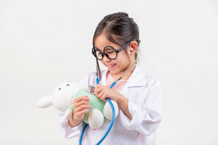 Asia little girl playing doctor and little rabbit doll isolated on whiteの写真素材