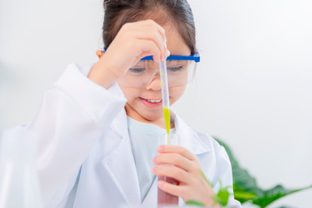 happy Asia little girl with flasks for chemistry science isolated on a white backgroundの写真素材