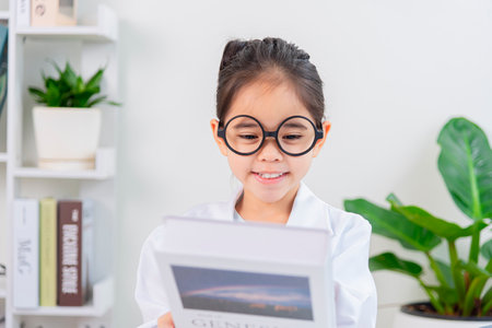 Cute Asia little Girl reading book for researchの写真素材