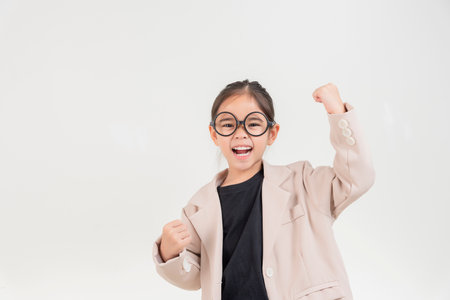 Little business lady Asia. Cute little girl in glasses and formalwear gesture happy standing on a white backgroundの写真素材