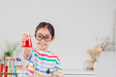little girl Wear a brightly colored shirt working with test tube science experiment in white roomの写真素材