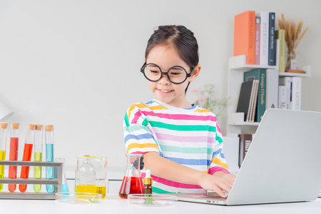 little girl Wear a brightly colored shirt working with test tube science experiment in white roomの写真素材
