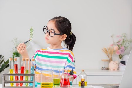 little girl Wear a brightly colored shirt working with test tube science experiment in white roomの写真素材