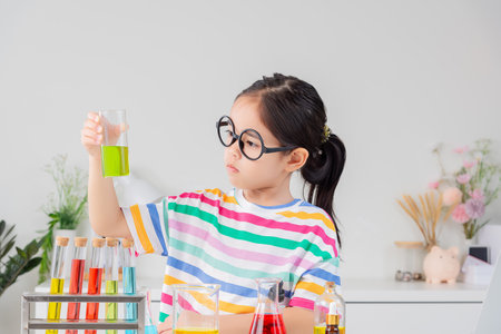 little girl Wear a brightly colored shirt working with test tube science experiment in white roomの写真素材