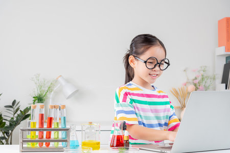 little girl Wear a brightly colored shirt working with test tube science experiment in white roomの写真素材