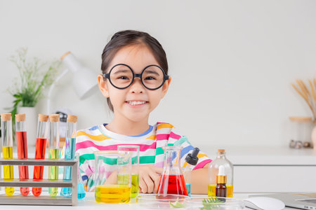 little girl Wear a brightly colored shirt working with test tube science experiment in white roomの写真素材