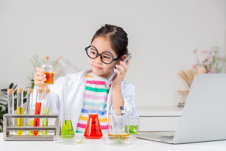 little girl Wear a science ground shirt working with test tube science experiment in white roomの写真素材