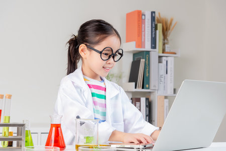 little girl Wear a science ground shirt working with test tube science experiment in white roomの写真素材