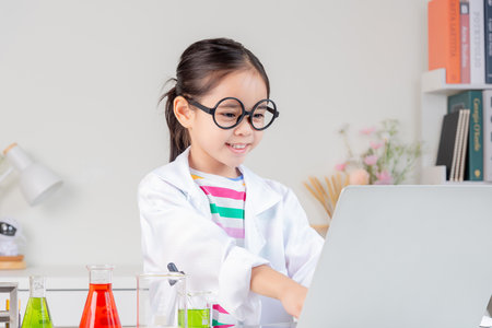 little girl Wear a science ground shirt working with test tube science experiment in white roomの写真素材