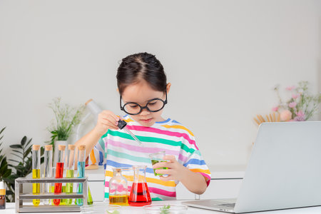 little girl Wear a brightly colored shirt working with test tube science experiment in white roomの写真素材