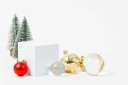 A Christmas tree is surrounded by a white box and a few ornaments. The scene is festive and cheerful, with the tree and ornaments representing the holiday seasonの写真素材