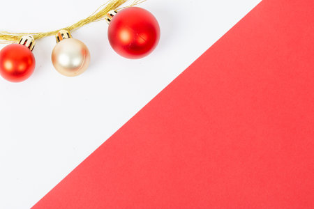 A red and gold ornamented Christmas tree with three red balls and a gold ornamentの写真素材