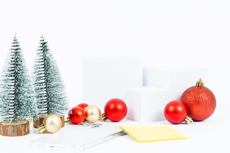 A white box with red and gold balls is placed on a white background. The box is accompanied by a yellow post-it note, which is placed on top of the box. Concept of organization and attention to detailの写真素材