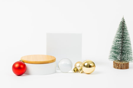 A white box with a red ball on top of it. The box is empty. There is a tree in the backgroundの写真素材