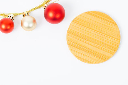 A wooden coaster with a red and gold ball on it. The coaster is surrounded by red and gold balls.の写真素材
