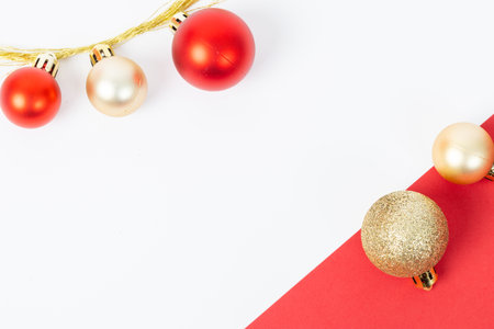 A red and gold ornament sits on a red background. The scene is festive and cheerful, with the red and gold colors evoking a sense of warmth and joyの写真素材