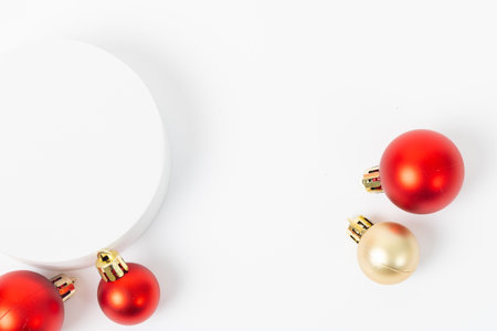 A white background with a red and gold ball and a red ball. The red balls are on top of a white surfaceの写真素材