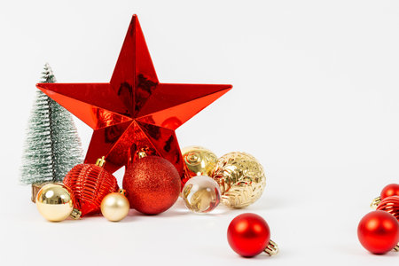 A red star is surrounded by many red and gold ornaments. The star is the focal point of the image, and the ornaments are scattered around it. Scene is festive and joyfulの写真素材