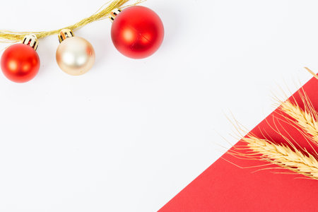 A red and gold ornament hangs from a string. The ornament is surrounded by a white background. The red and gold color scheme creates a festive and joyful moodの写真素材
