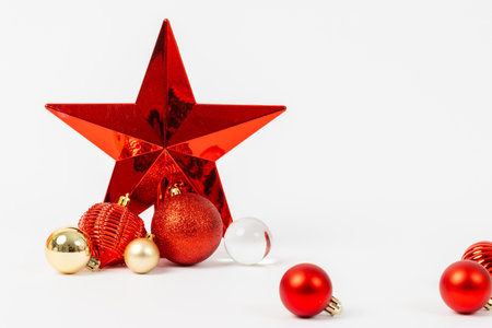 A red star is surrounded by many red and gold ornaments. The star is the focal point of the image, and the ornaments are scattered around it. Scene is festive and celebratoryの写真素材