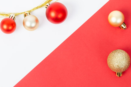 A red and white background with a row of red and gold ornaments. The red and white background is a contrast to the gold and red ornaments, creating a festive and cheerful atmosphereの写真素材