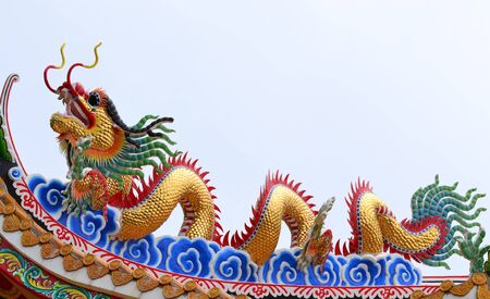 Golden Dragon. on the roof with blue sky at Chinese shrine ,Thailand.の写真素材