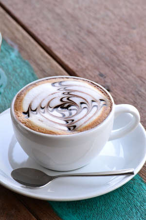 Cup of coffee with artistic cream decoration