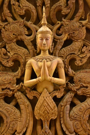 An ancient mural wood carving in Thai temple.の写真素材
