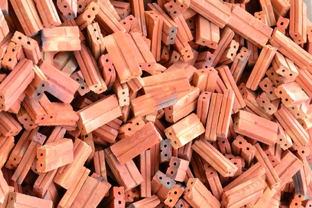 Bricks and blocks stacked on ground.
